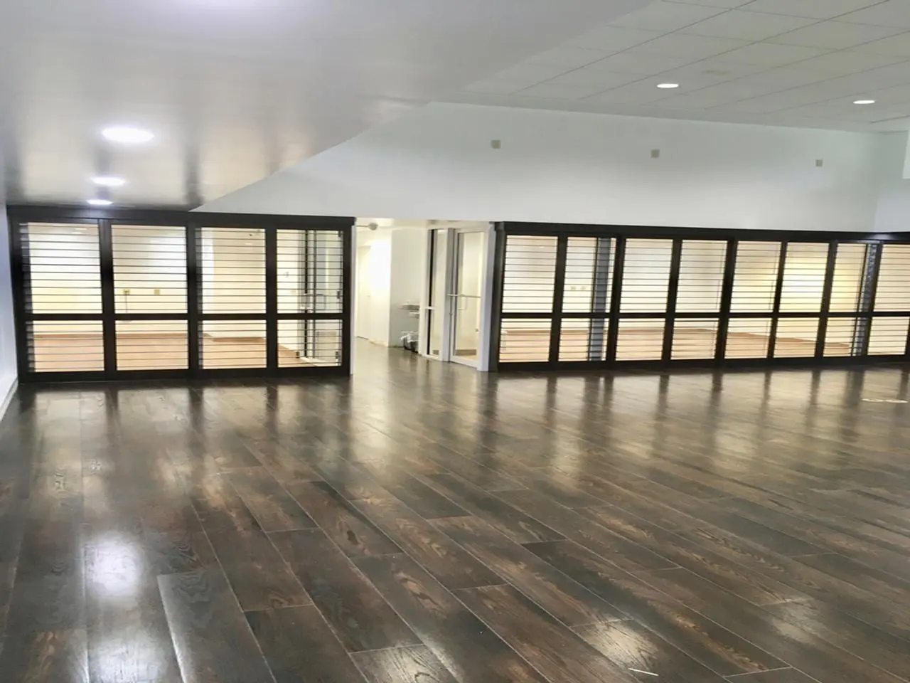 Commercial building with plantation shutters used as room divider with the louvers opened