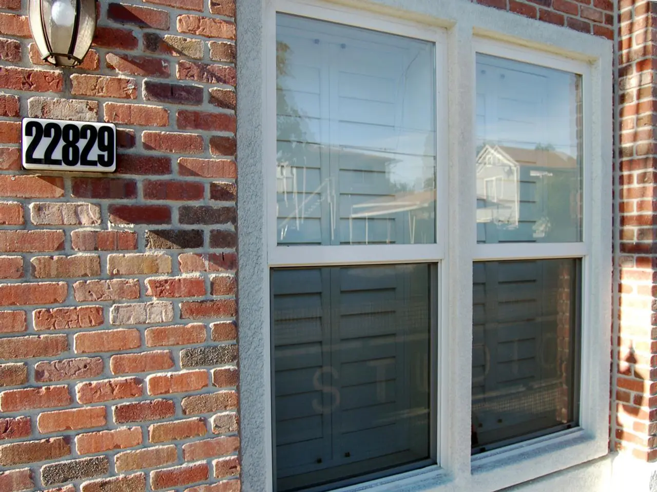 Outside view of brick home with interior shutters on the windows