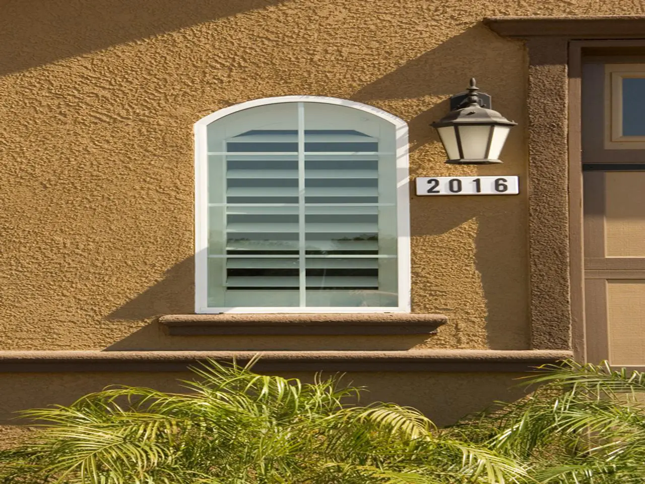 Close up view of exterior view of shutter on an arched window