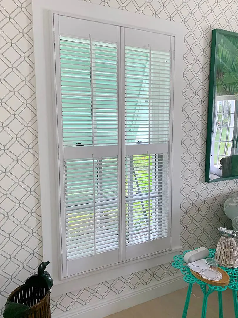 floor to ceiling plantation shutters in a bedroom