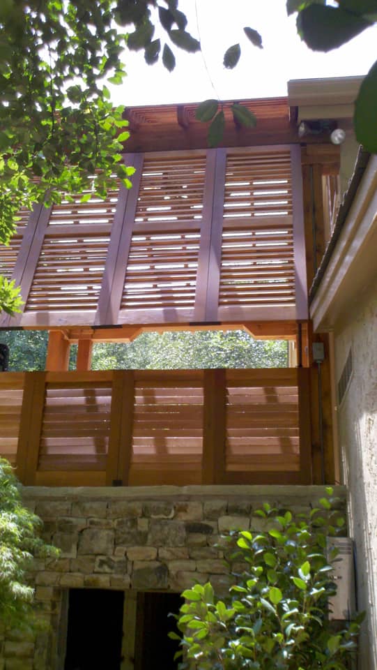 Stained wood Bahama shutters on porch