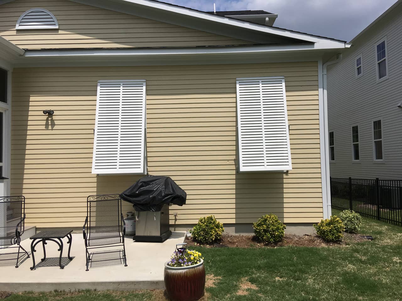 Bahama shutters on house with patio
