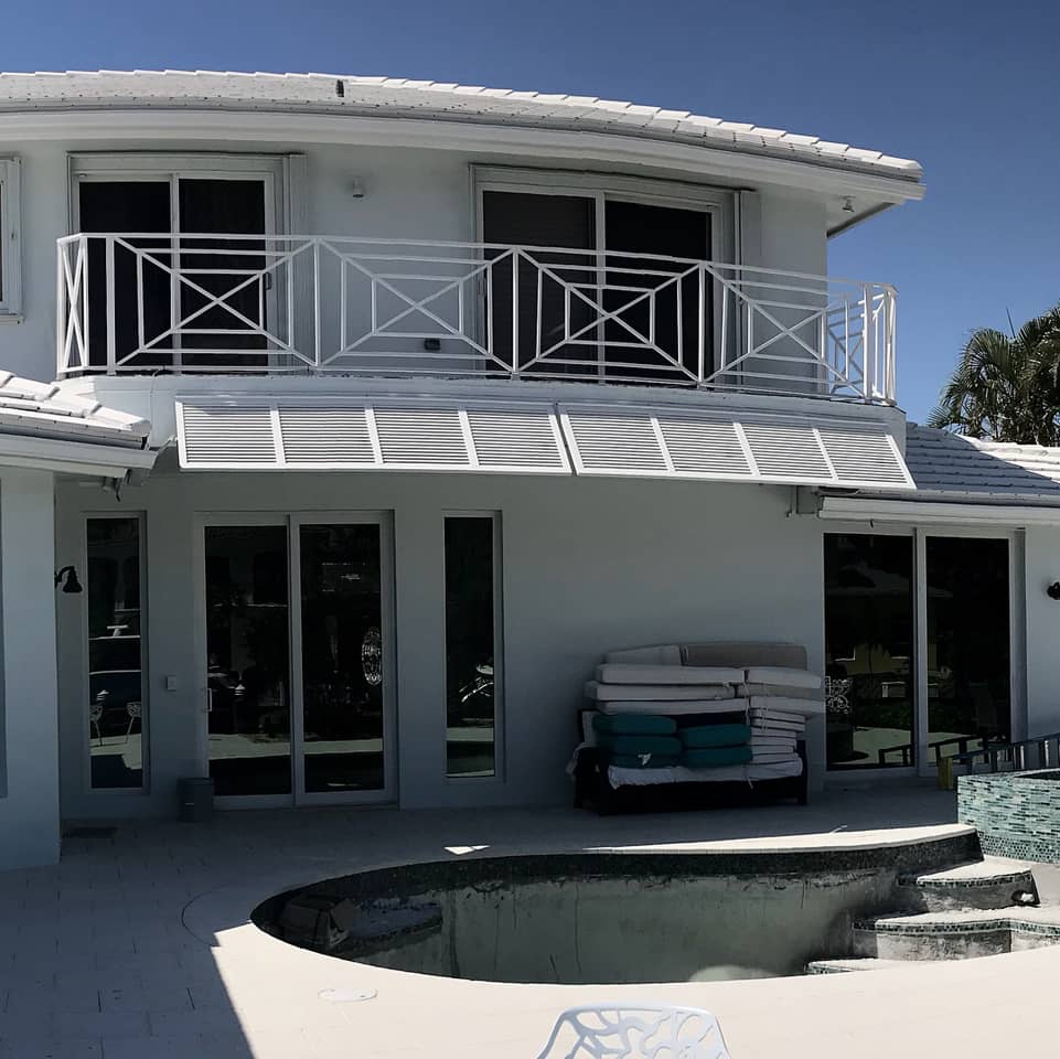 Bahama shutters on a house with patio