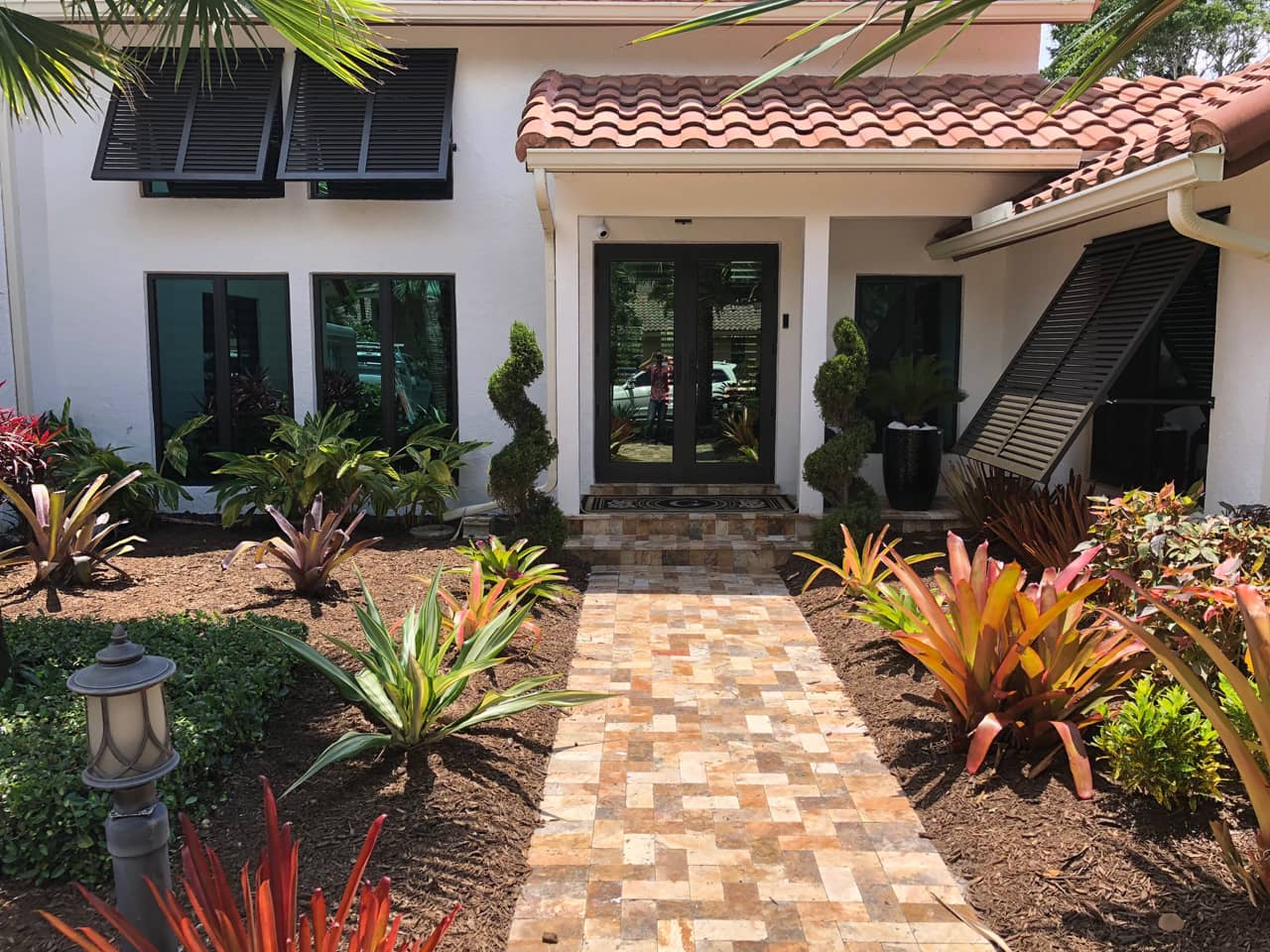 Entryway to mediterranean style house with Bahama shutters