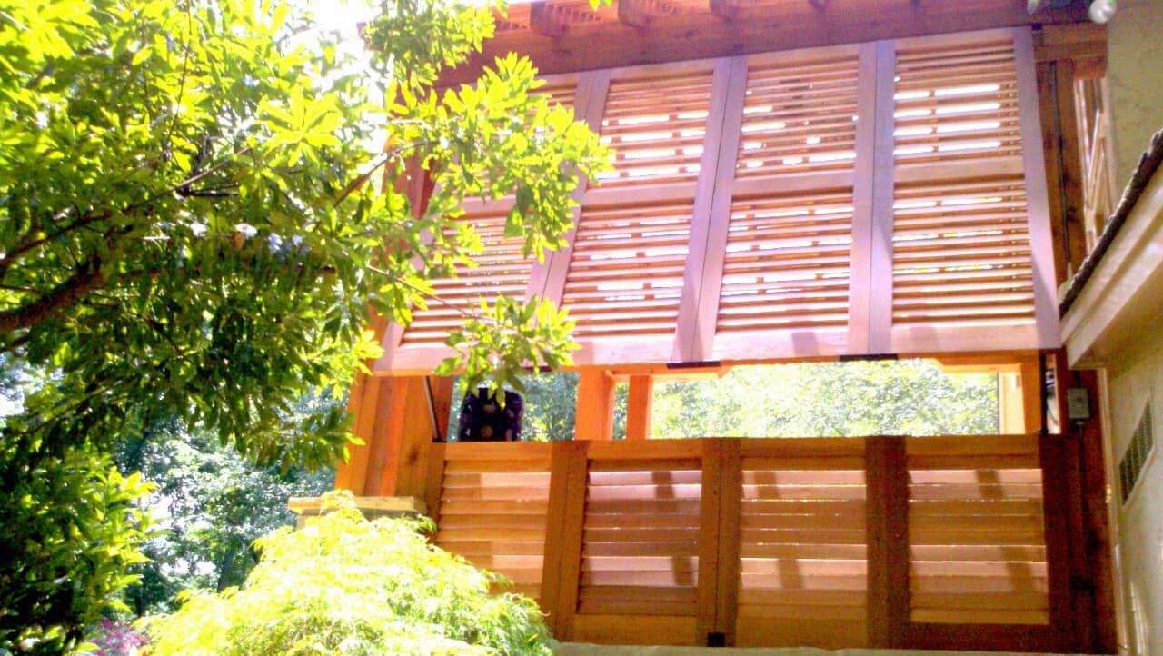 Stained wood Bahama style shutter on a house