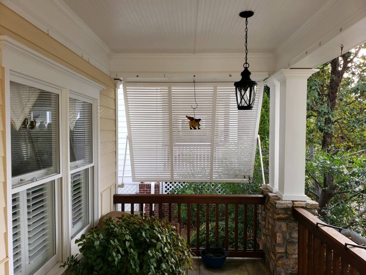 Bahama shutters on the side of a front porch