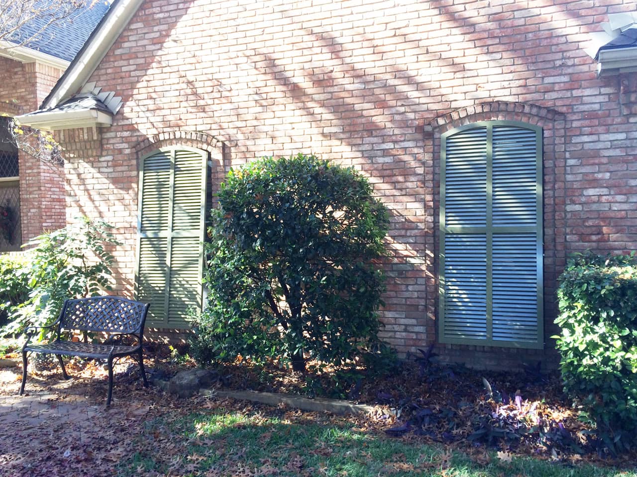 Arched Bahama shutters on a brick house