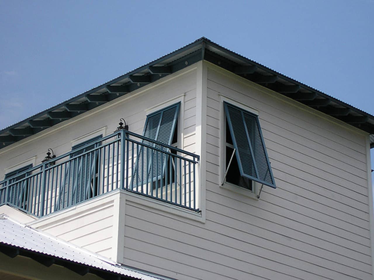 Bahama shutters on second story of a house