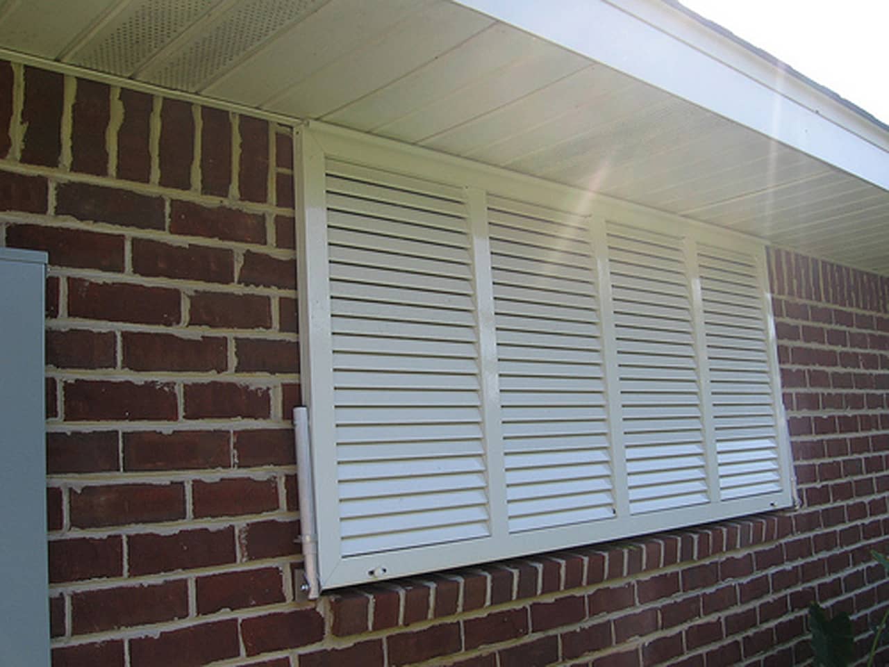 White Bahama shutters on a brick house