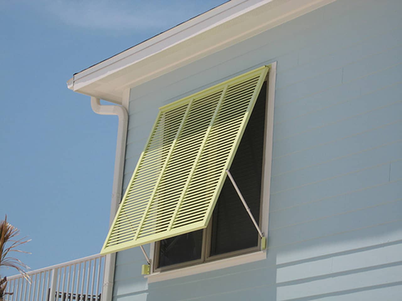 Bright green Bahama shutters on a house