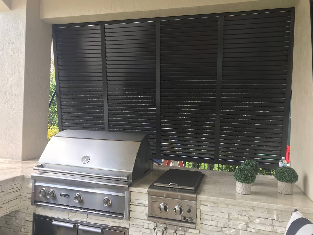 Bahama shutters in outdoor kitchen