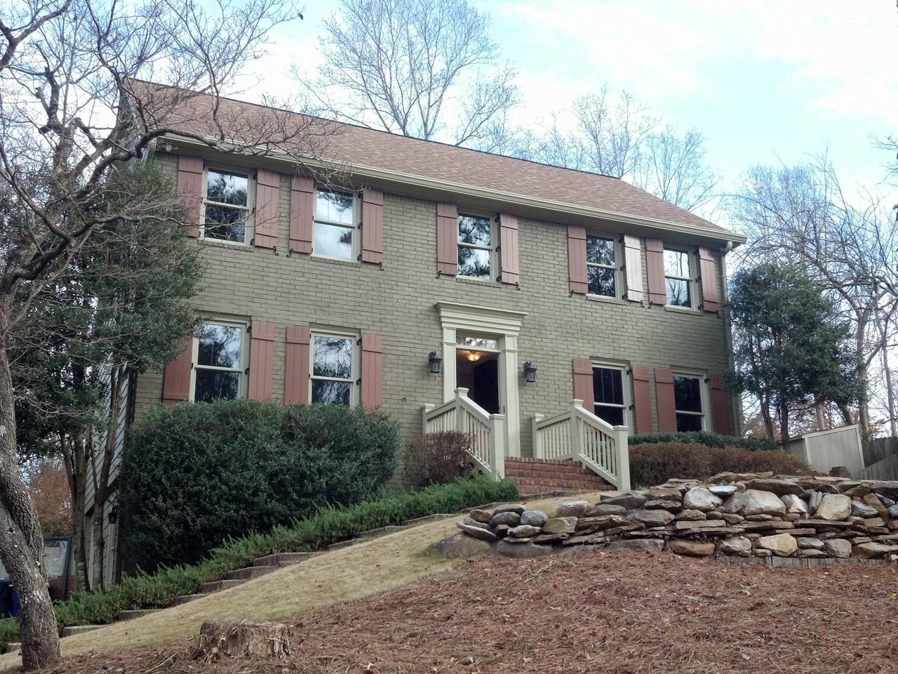 Board and batten shutters on painted brick house