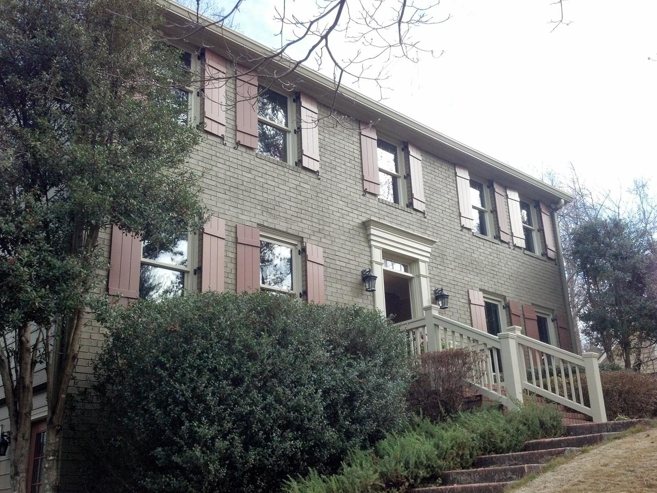 Board and batten shutters on a brick house