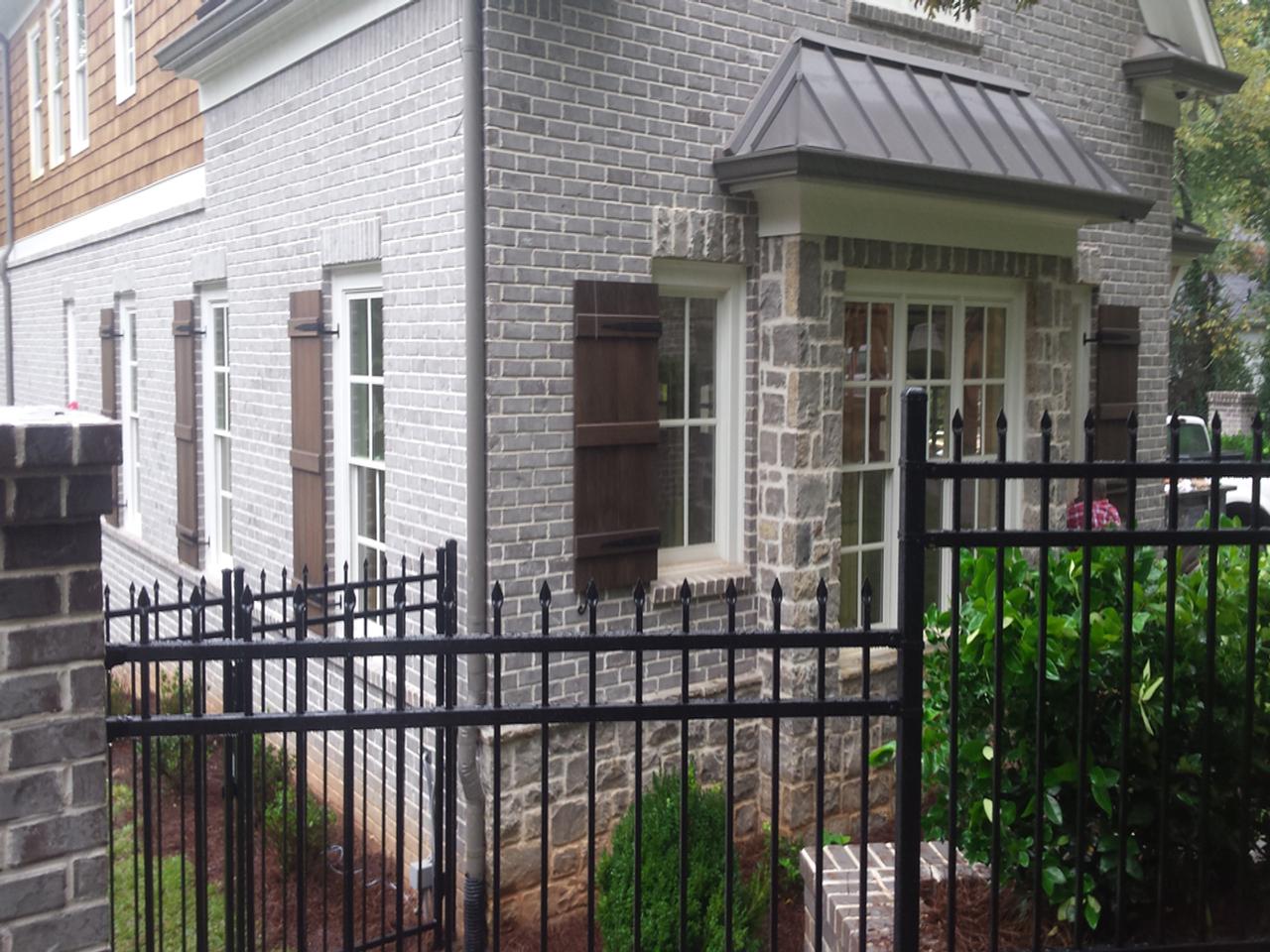 Board and batten shutters on brick and stone house