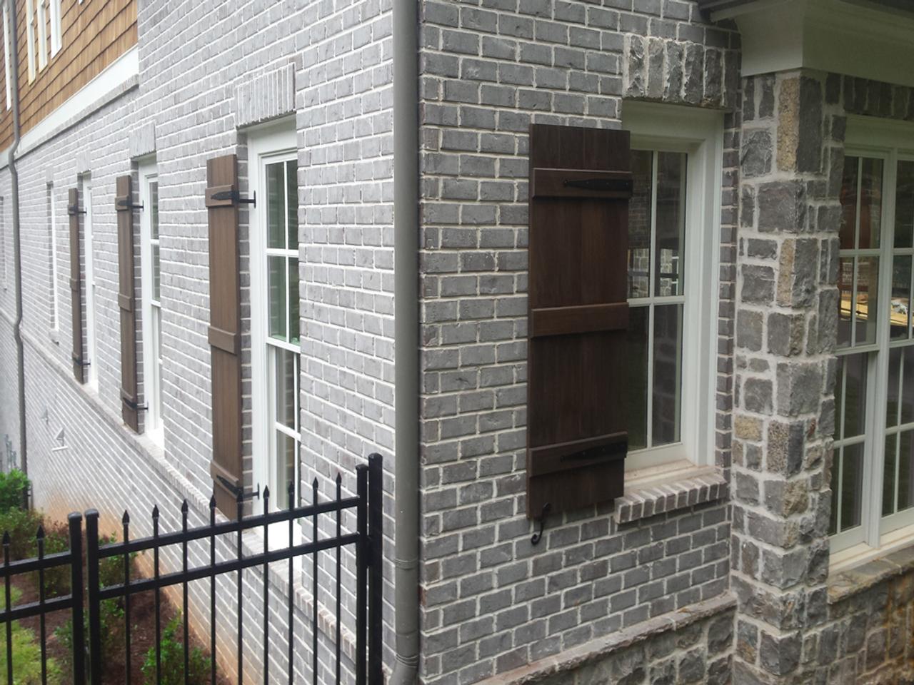 Board and batten shutters on a brick house