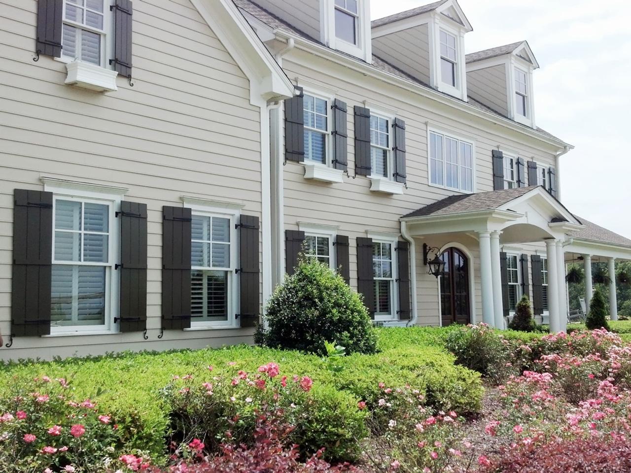 Board and batten shutters on house with siding