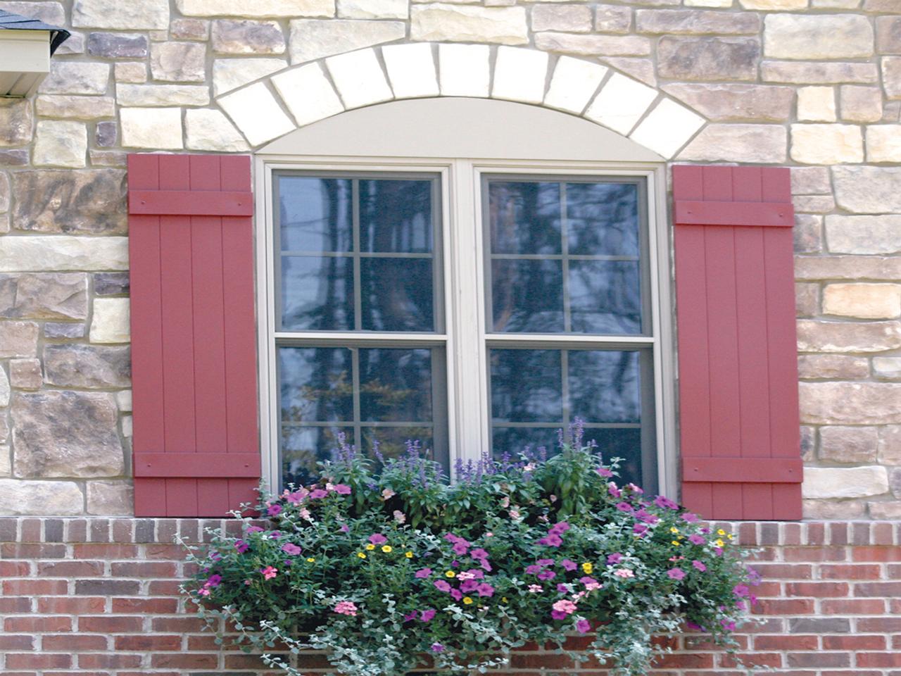 Board and batten shutters on stone and brick house