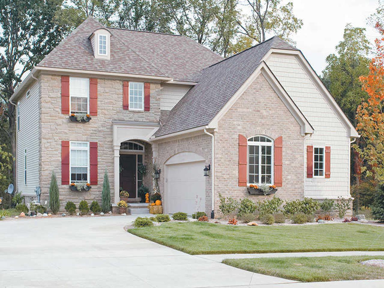 Board and batten shutters on stone and siding house