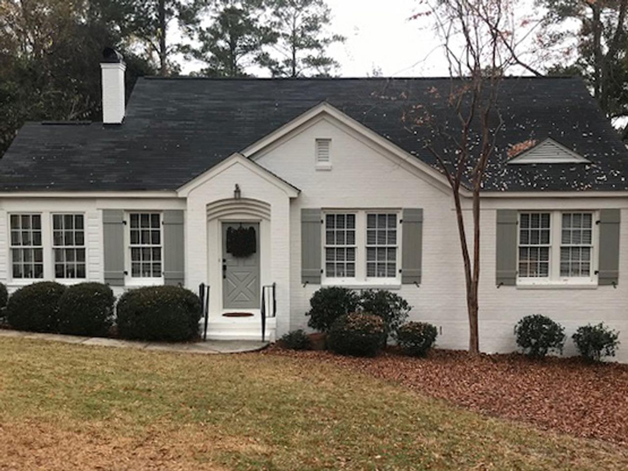 Board and batten shutters on white painted brick house