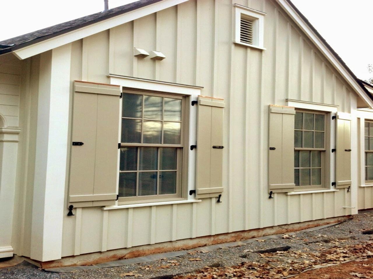 Operable board and batten shutters on house with vertical siding