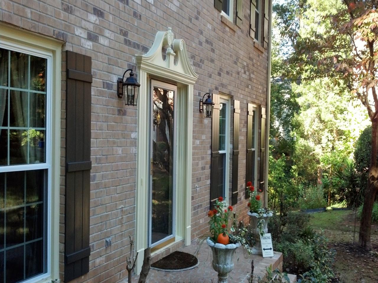 Decorative board and batten shutters on a brick house