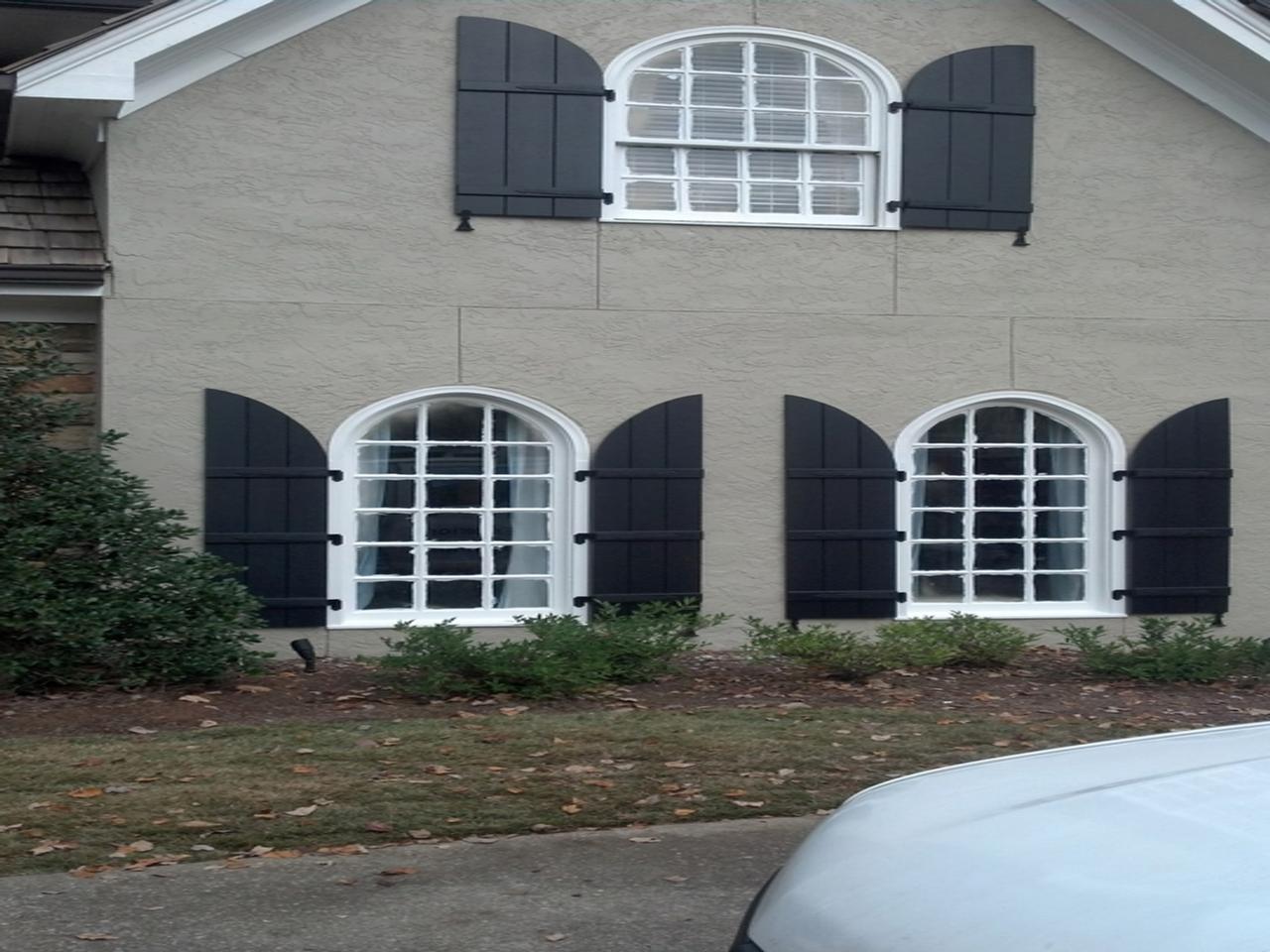 Arched board and batten shutters on a home