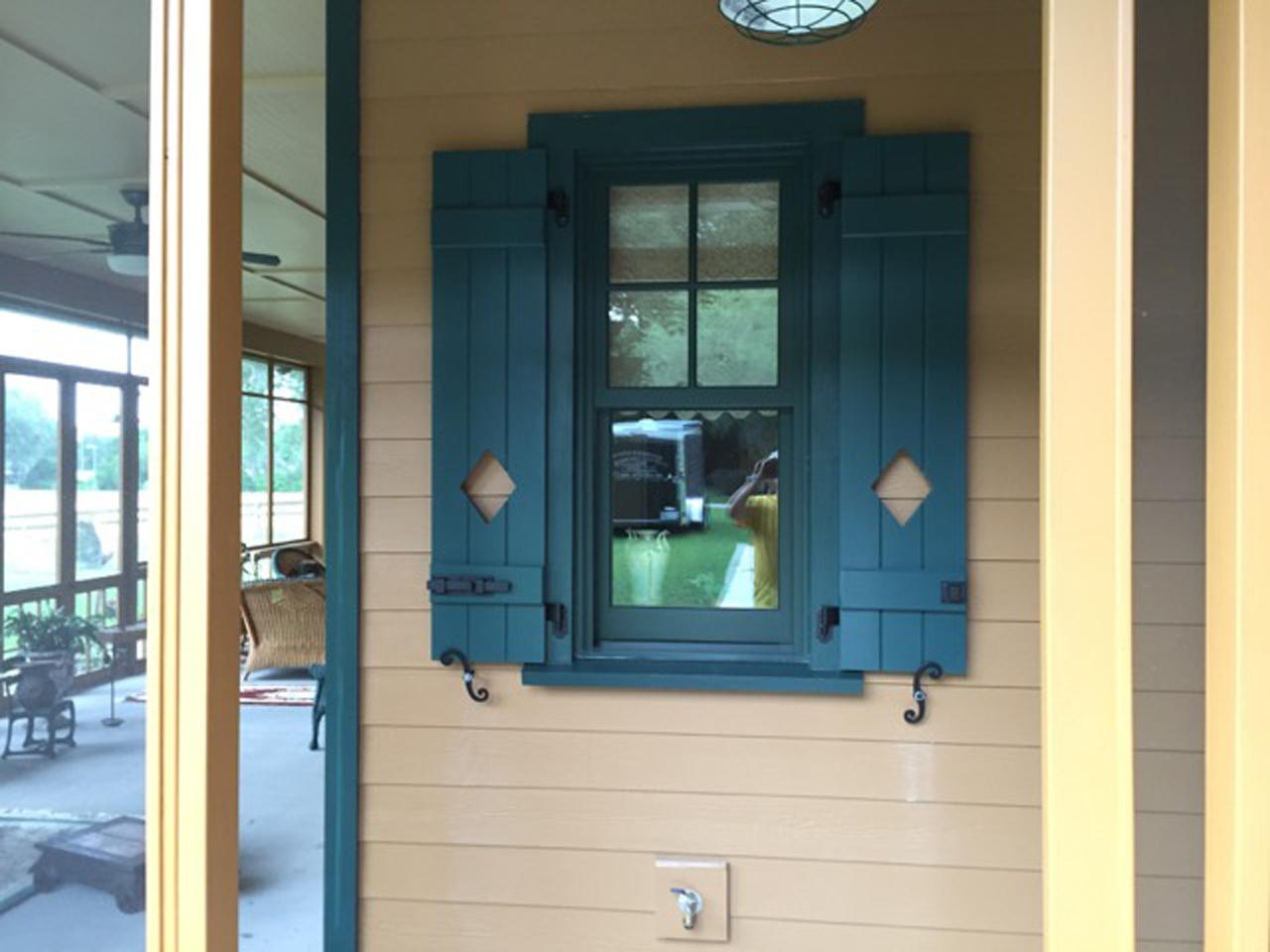 Board and batten shutters with cutout on a porch