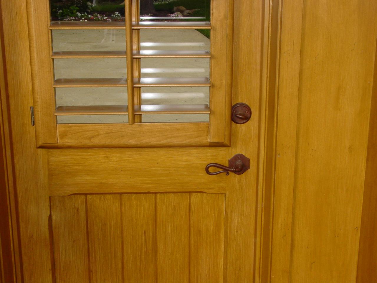 Stained shutters on the top of a door with a window