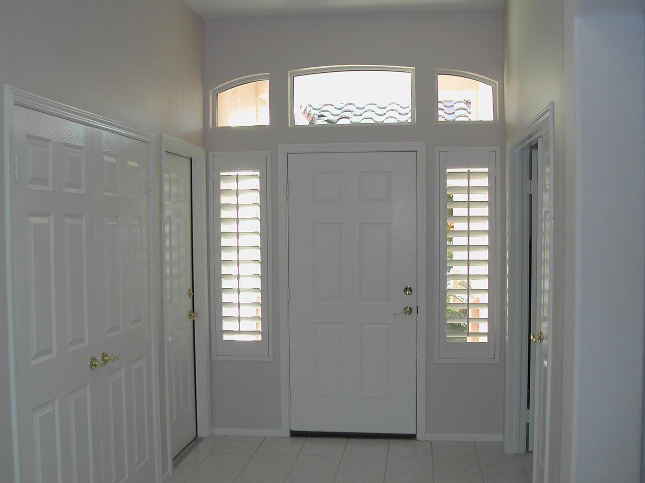 Sidelights by a front door with plantation shutters