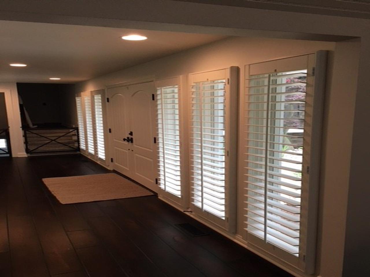 Windows by double front doors covered with plantation shutters