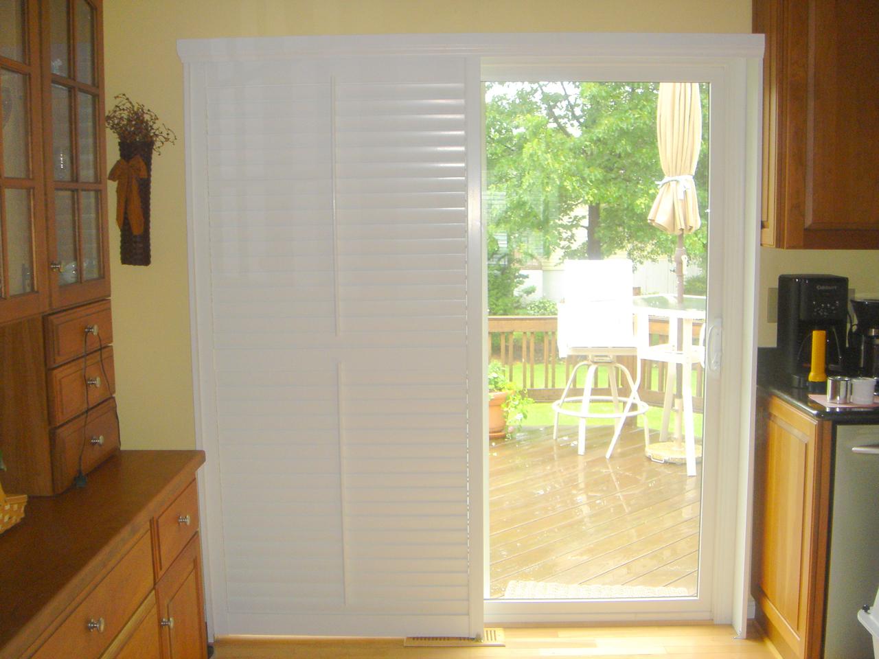 Bypass shutters on sliding glass door with the louvers closed and part of the shutters to the side