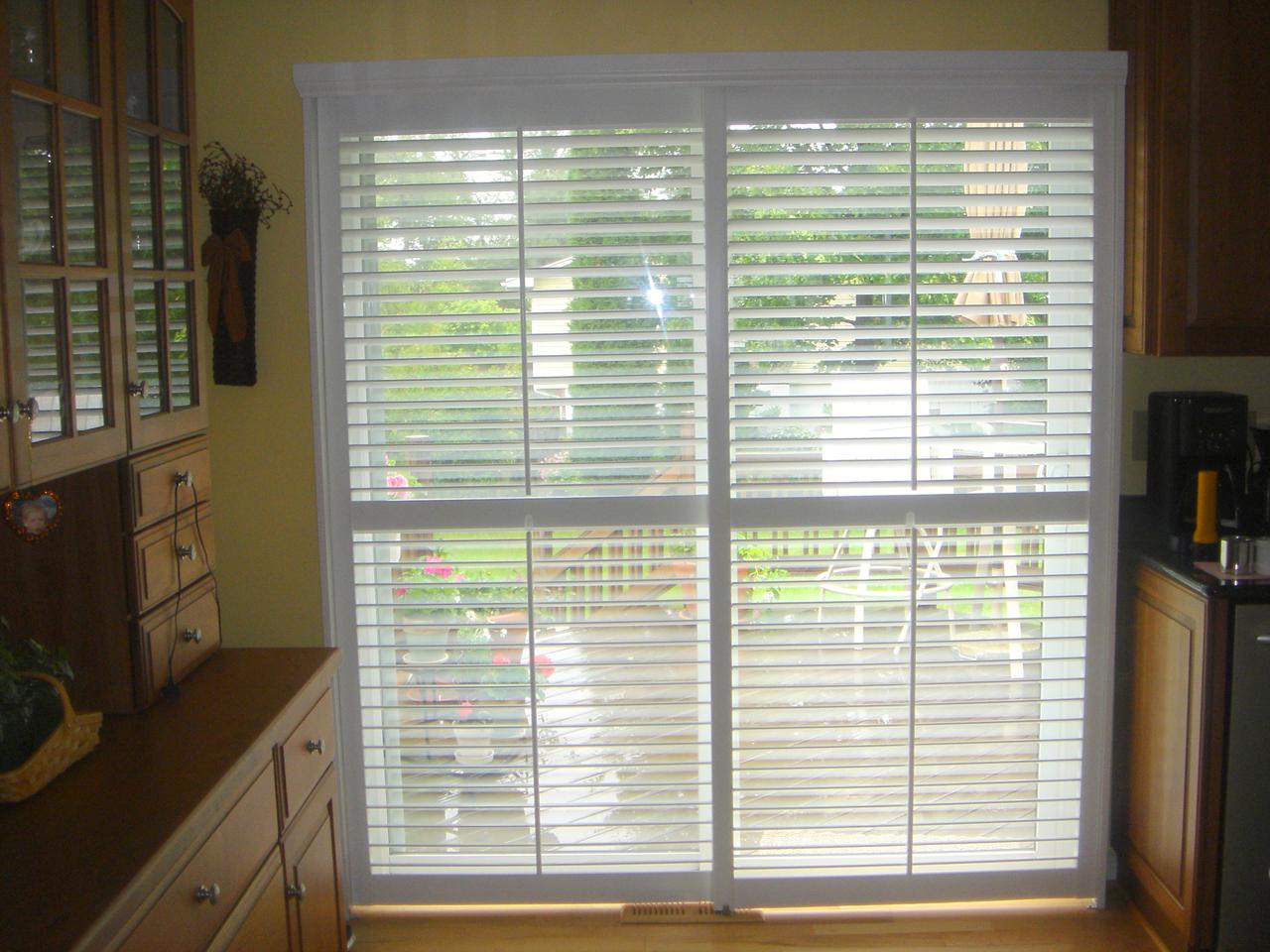 Bypass shutters closed with louvers opened on a sliding glass door in a kitchen