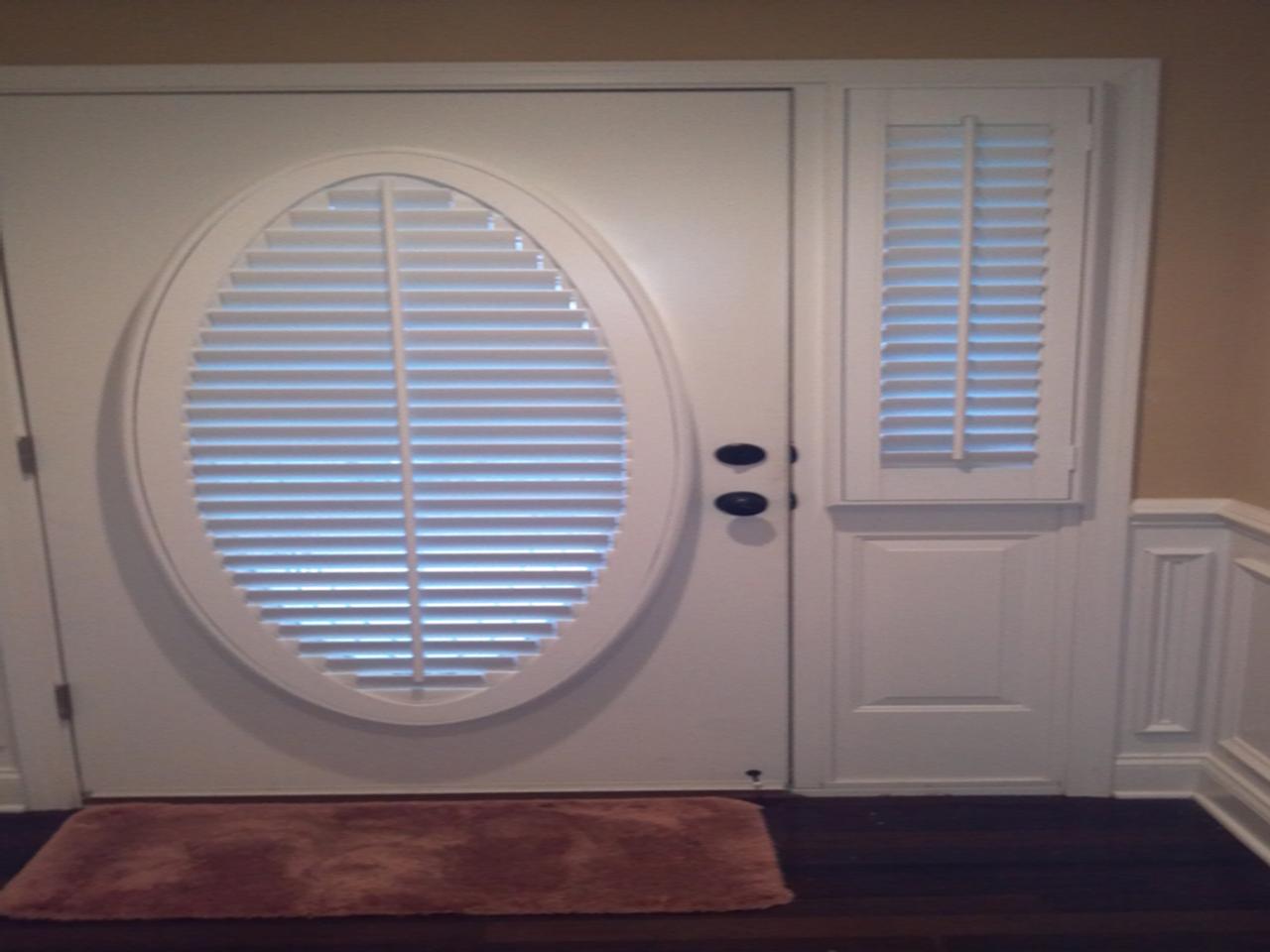 Front door with oval glass and sidelights with interior shutters