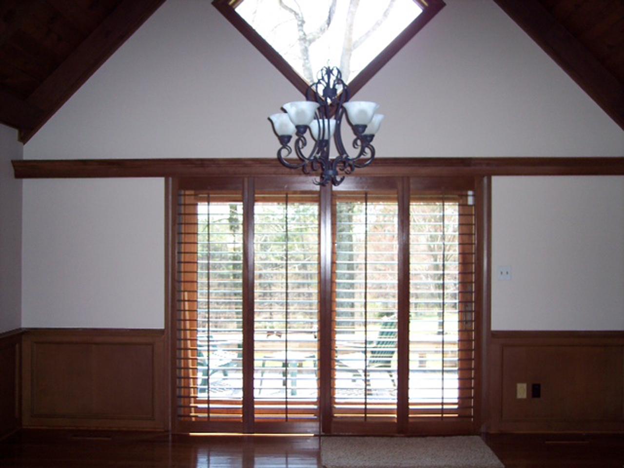 Stained wood folding shutters on a sliding glass door