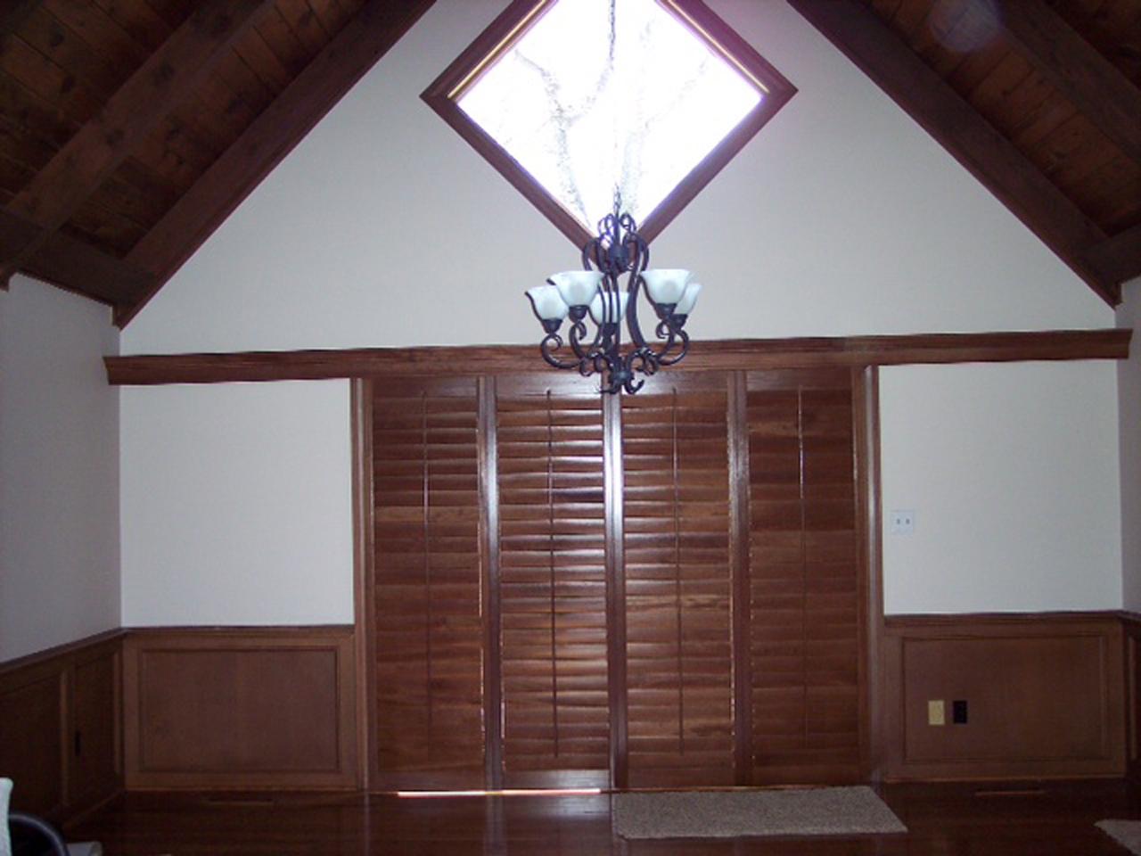 Stained plantation shutters on sliding glass doors with louvers closed