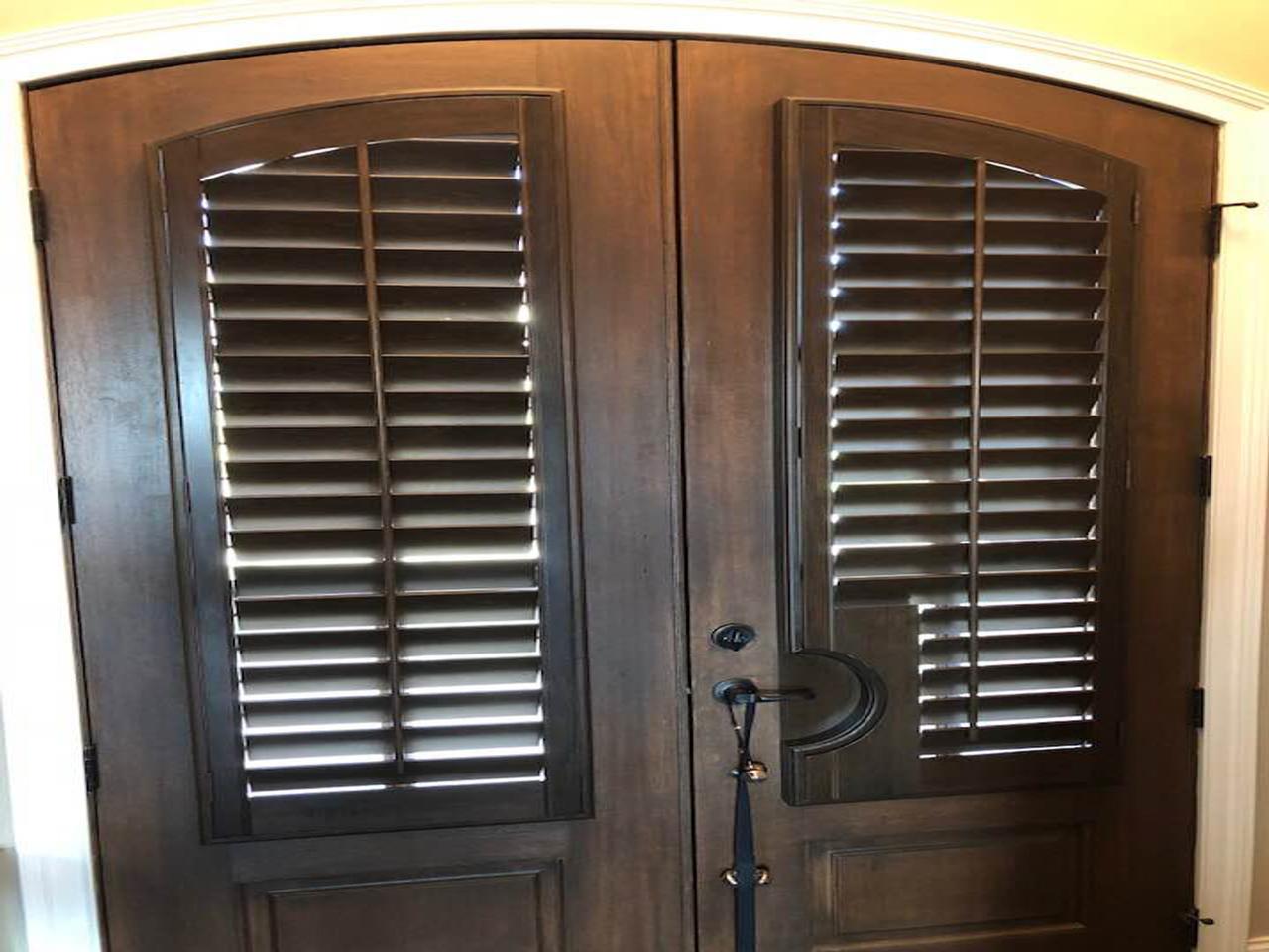 Arched stained shutters on French doors