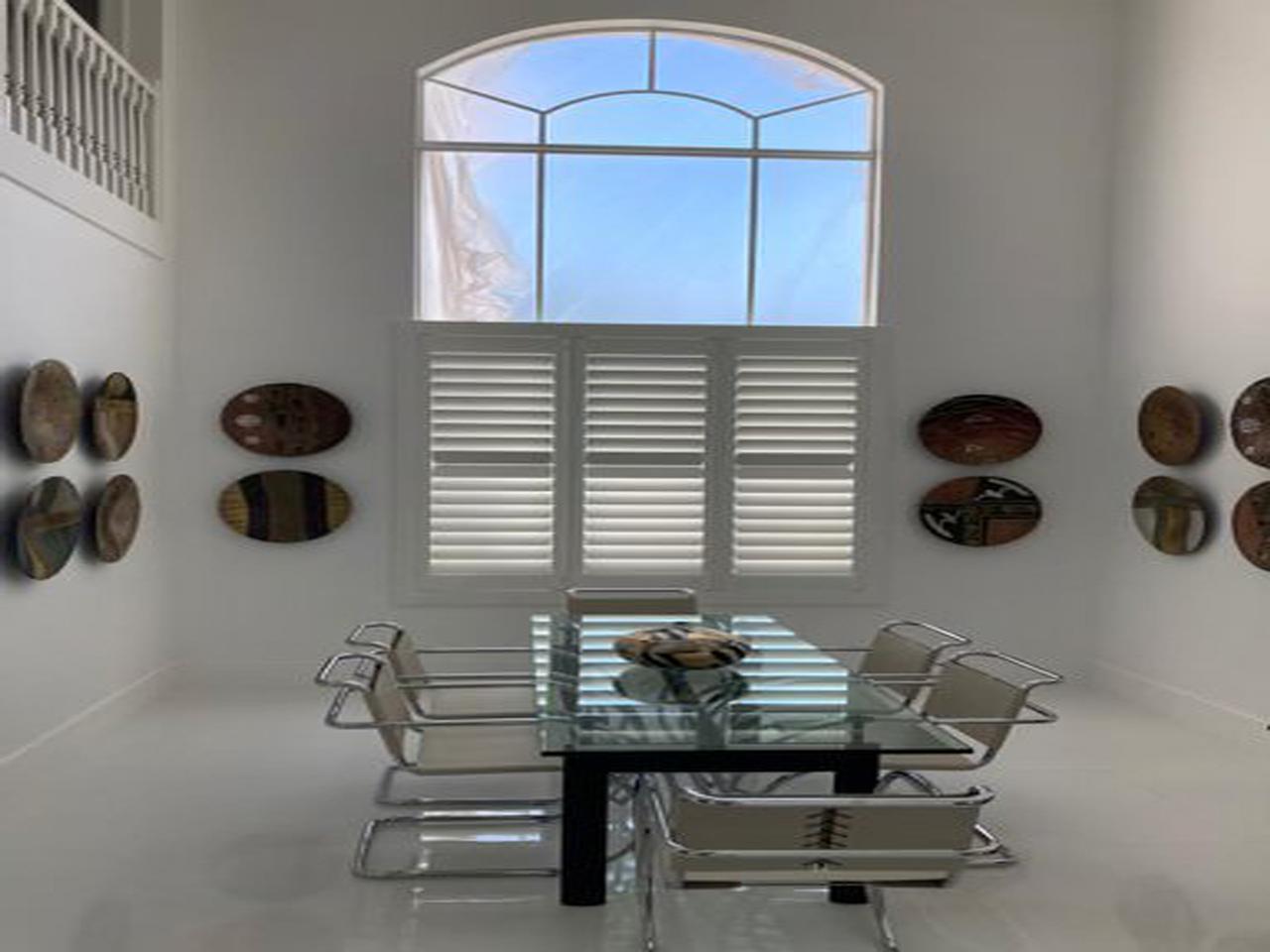 Dining room with arched window and shutters