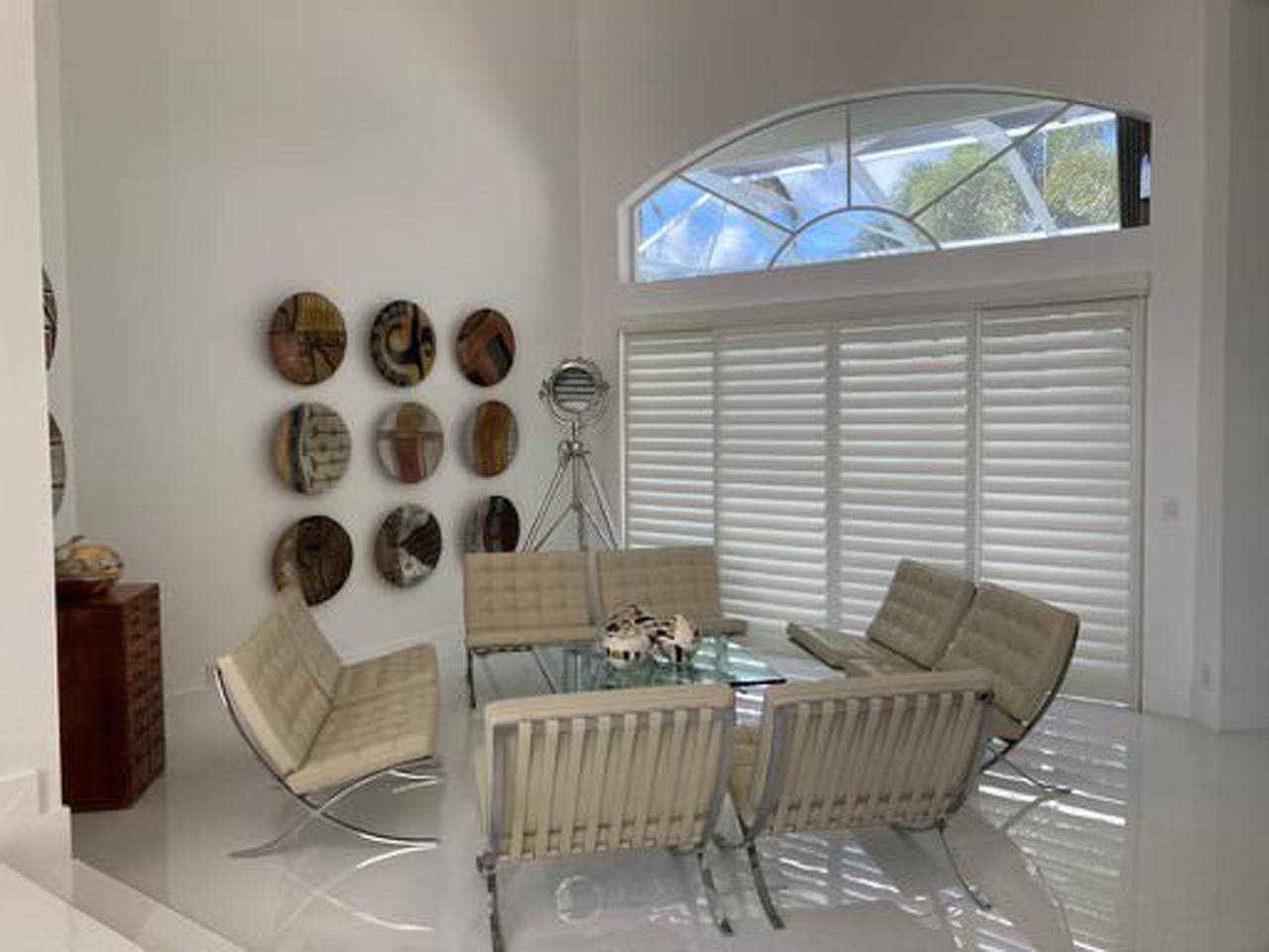 Dining room with shutters on sliding glass doors with arch