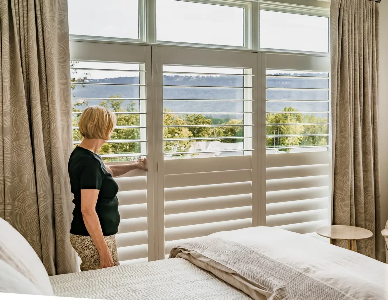 woman opening plantation shutters