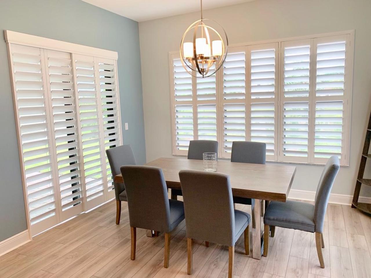 Dining room with plantation shutters on windows and French Door