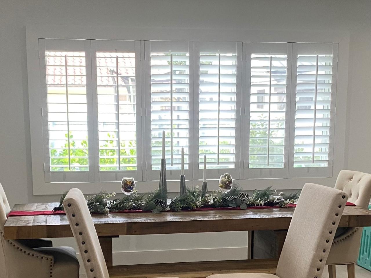 Dining room with shutters on large window