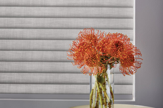 Flowers in front of Sonnette cellular roller shades