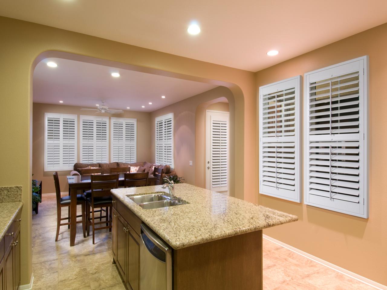 Open concept kitchen, dining and living room with windows and French Doors with interior shutters