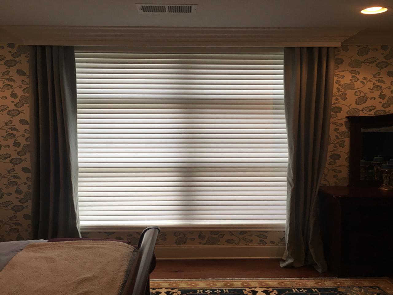 Double window with blinds in a bedroom