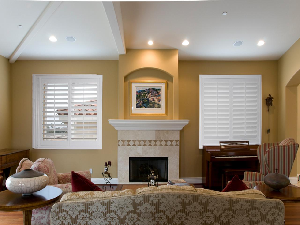 Plantation shutters on either side of fireplace with one with louvers open, one with louvers closed