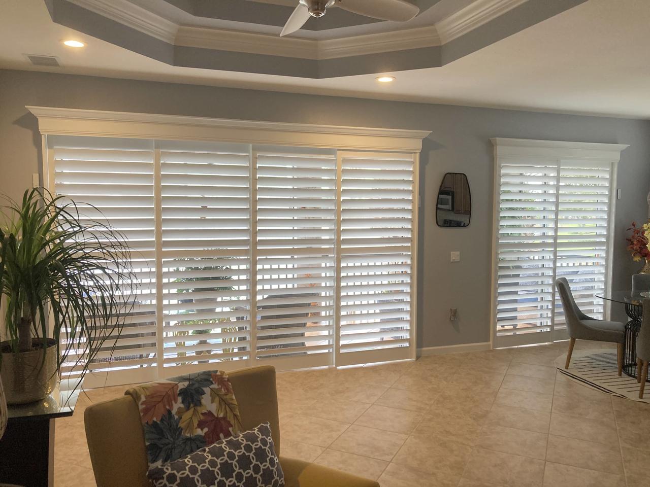 Living room/dining room with sliding glass doors with shutters