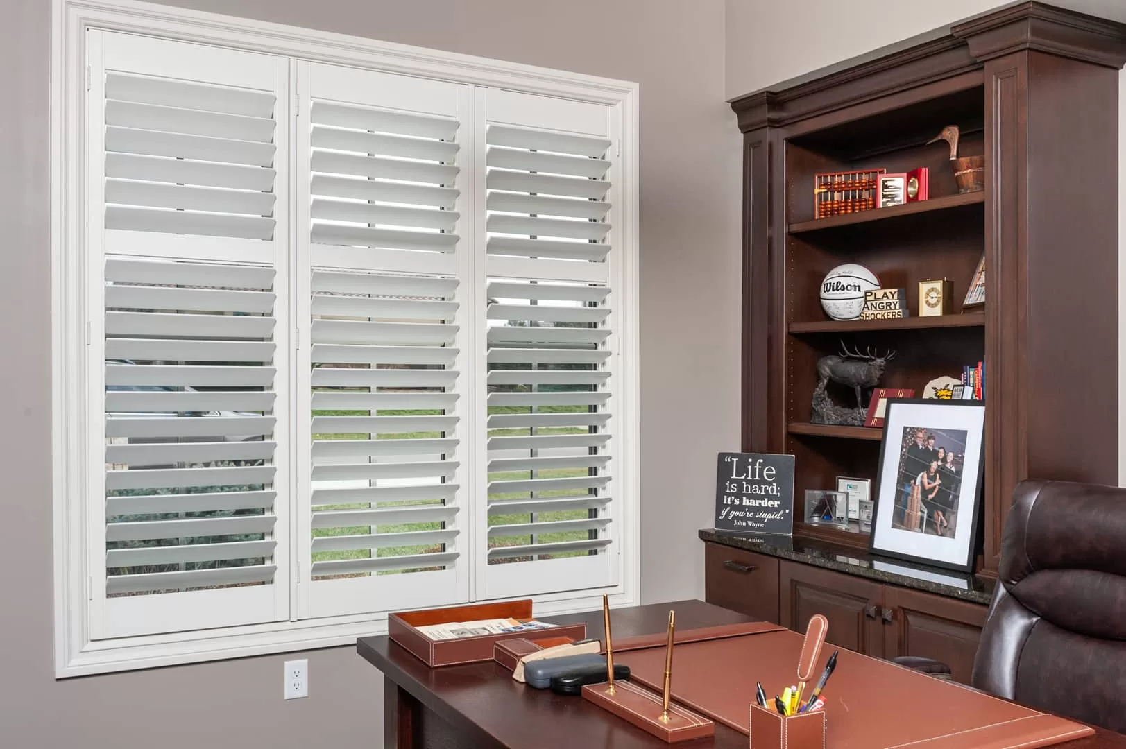 Heritage wood shutters on a home office window