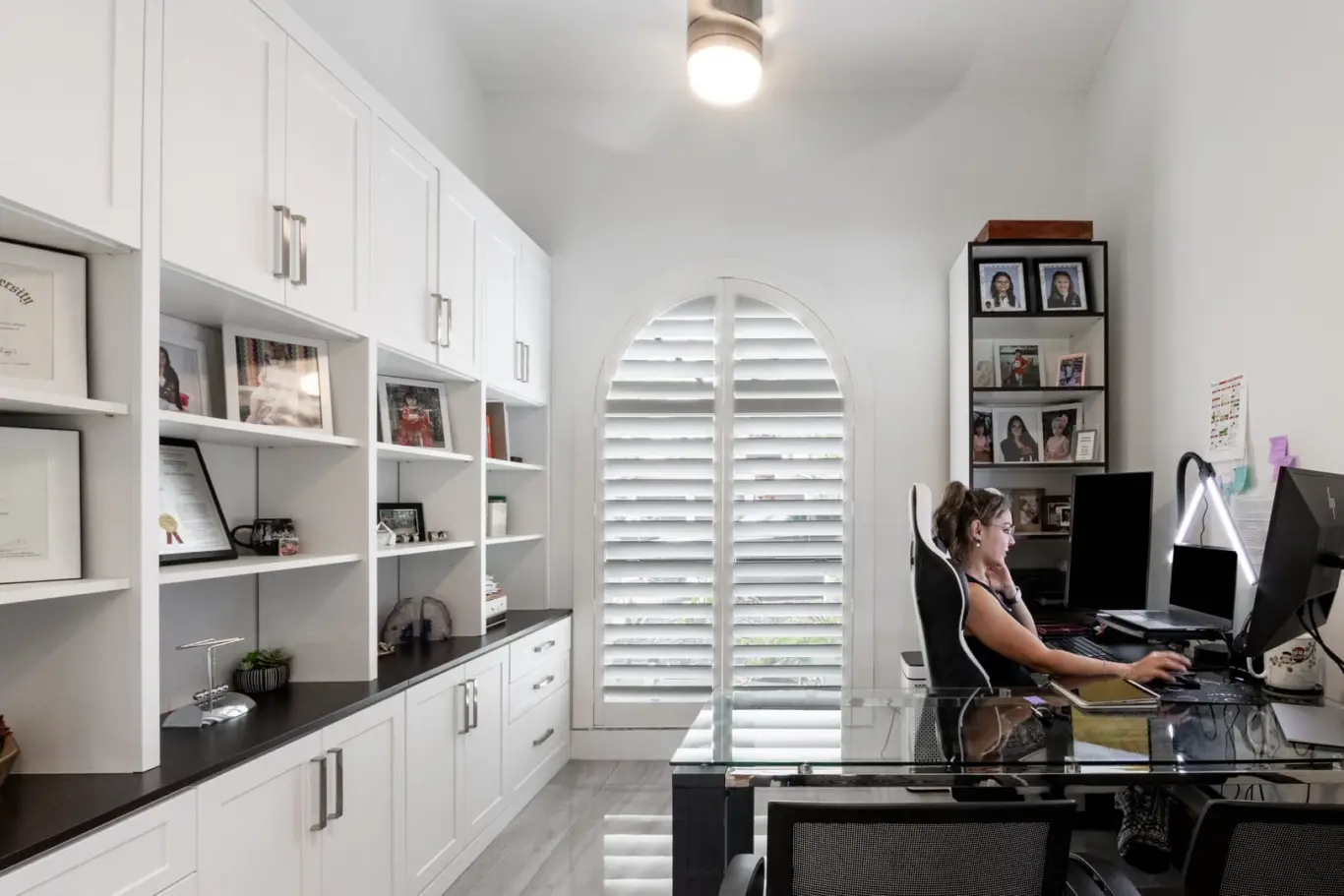 Office with plantation shutters on an arched window