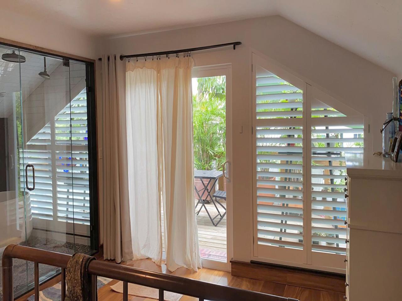 Louverwood shutters in bedroom on slant topped window