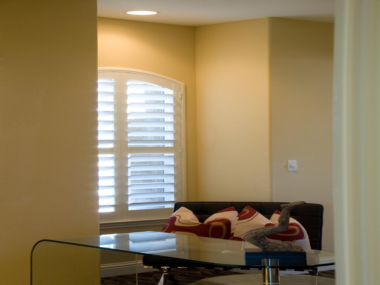 Arched window with interior shutters in a home office